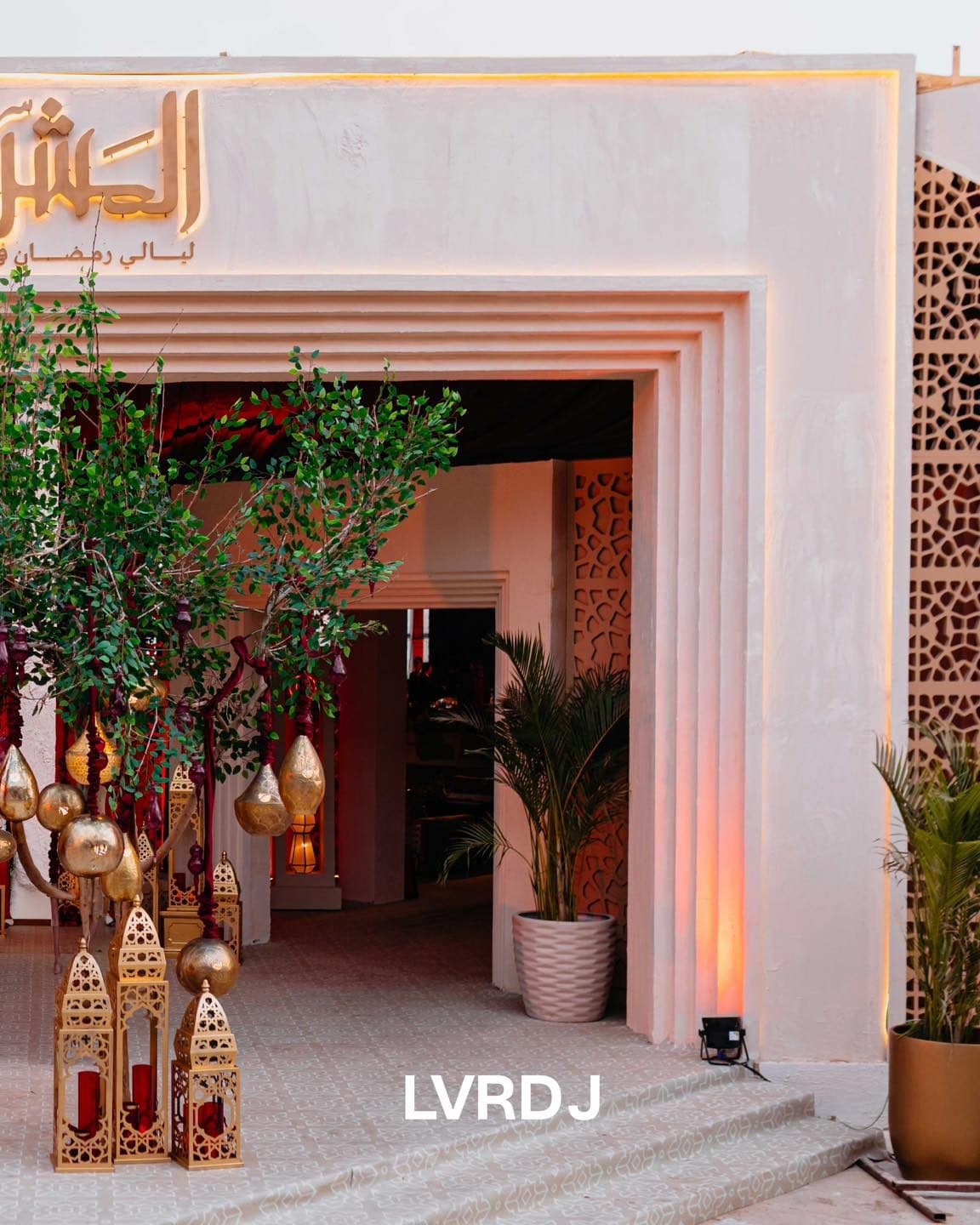 Carved white entrance with lantern tree