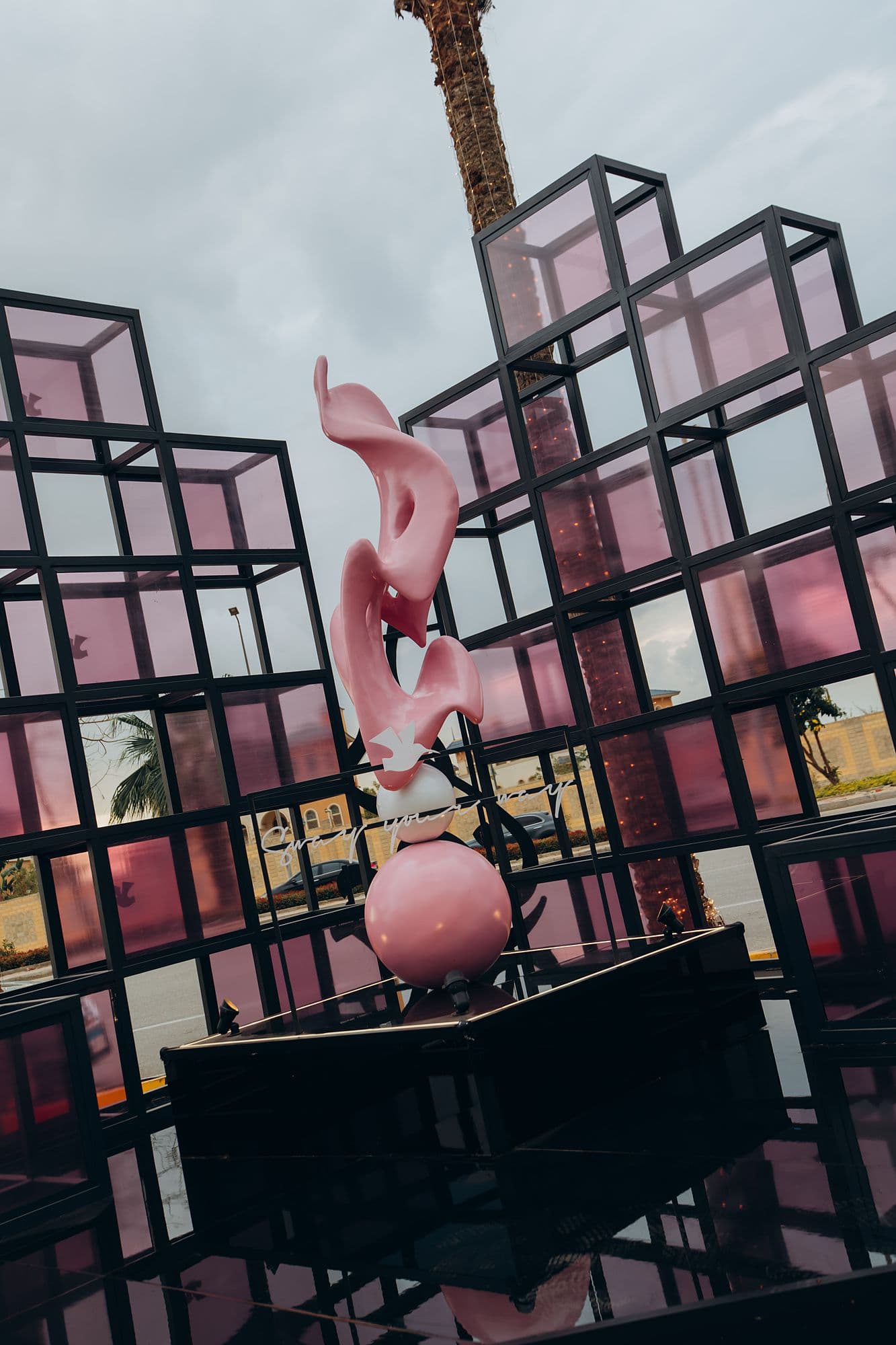 Close-up of the pink calligraphy sculpture inside its steel cube